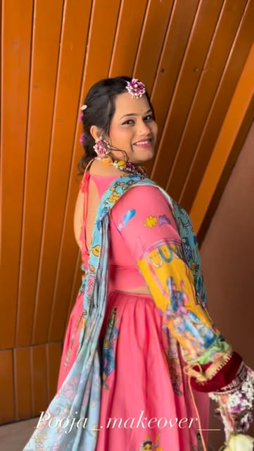 A colourful pink and blue outfit, long styled hair and a floral hair accessory, from Pooja Salunkhe Makeover's portfolio