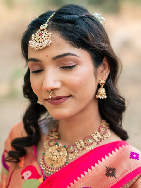 Close bridal portrait with a pink sari, softly defined eyes and gold jewellery, from Pooja Salunkhe Makeover's portfolio